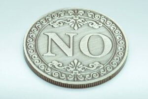 a decorative coin with the word "NO"