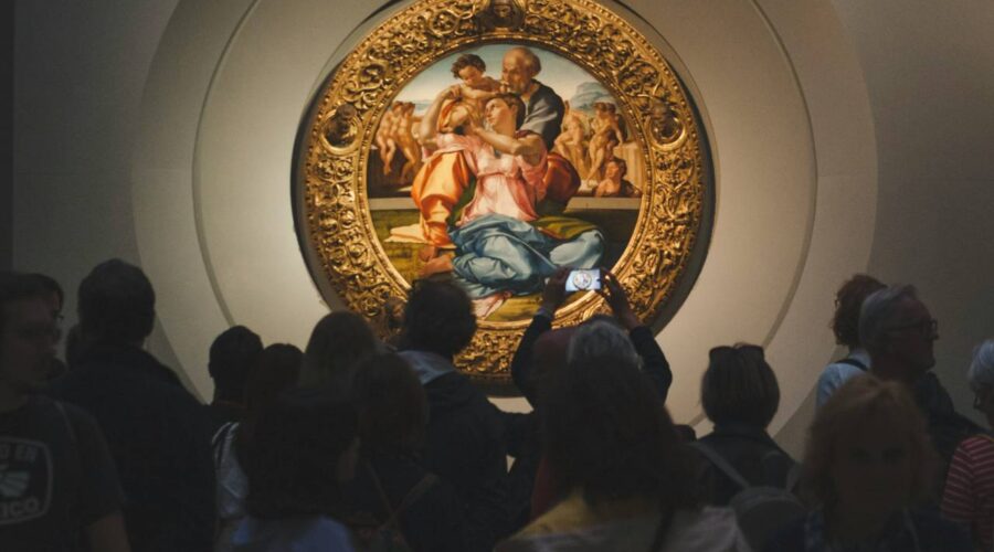 People looking at a painting of the Holy Family.