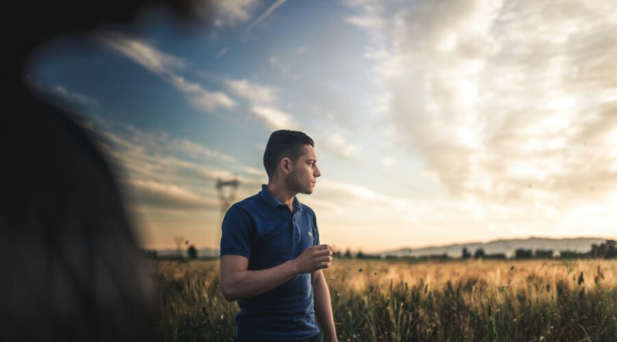 a man in a blue polo shirt in a field