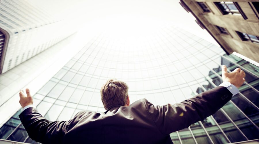 a man looking at the sky surrounded by tall buildings