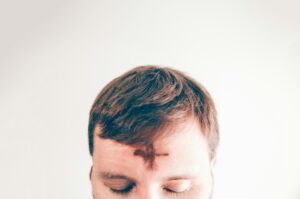 a person with an ash cross on his forehead