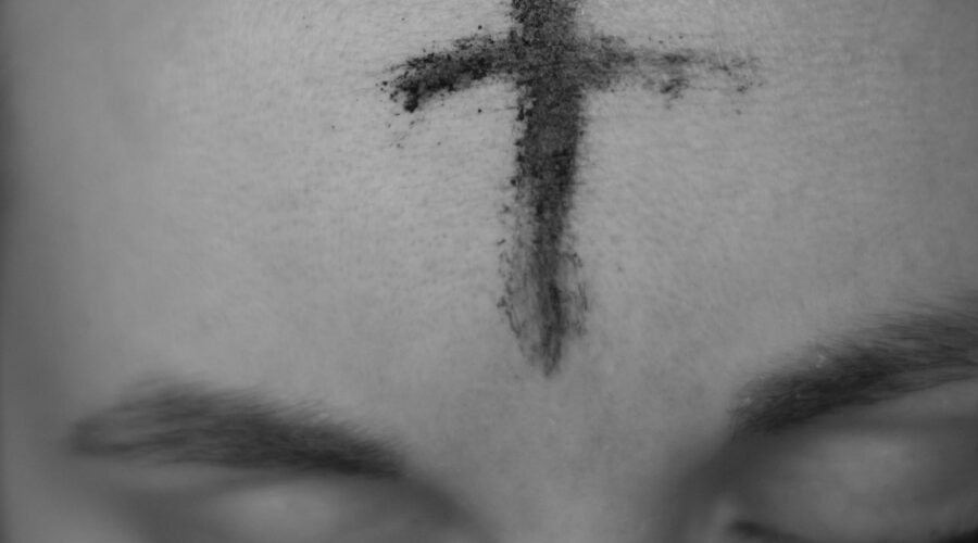 a photo of a cross in ashes on a person's forehead.