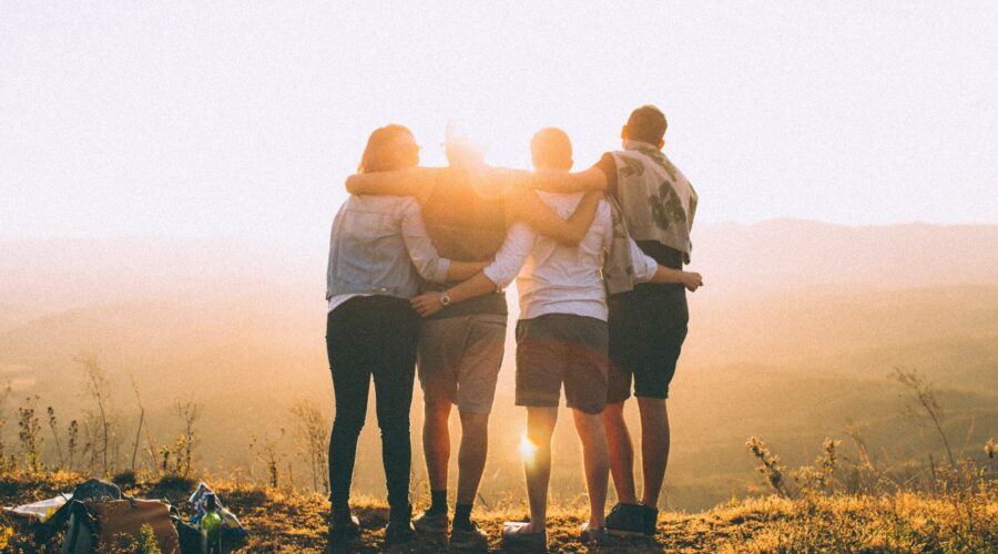 "Elections" - a photo of four people, arms around each other, facing the sun