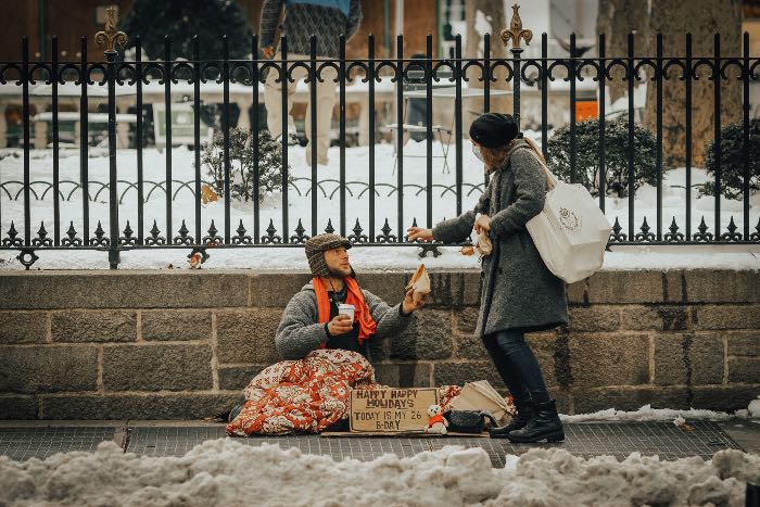 "Sharing" - a photo of a person giving to someone in the cold. His sing reads "Happy Happy Holidays - Today is my 26 B-Day"
