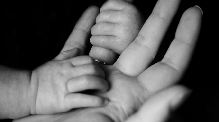 a photo of a baby holding a parent's hand