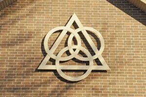 a photo on the exterior of a church, with the interlocking symbols of the trinity.