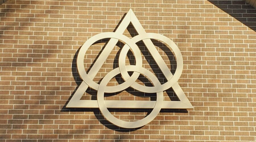 a photo on the exterior of a church, with the interlocking symbols of the trinity.