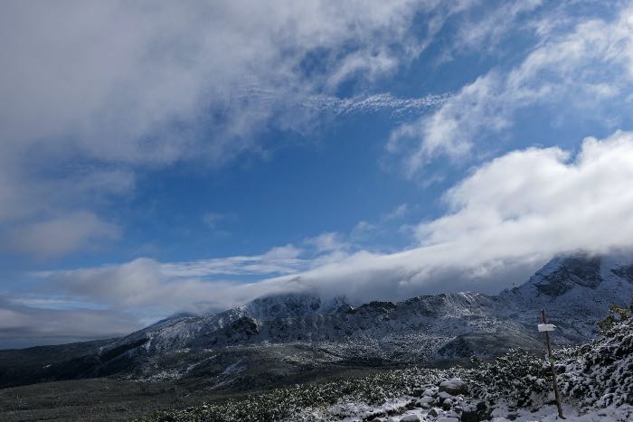 "listening" - a photo of a mountain and above it, clouds.